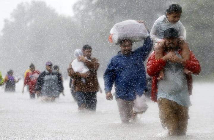 Residents wade through flood waters from in Beaumont Place, Houston, on Monday.