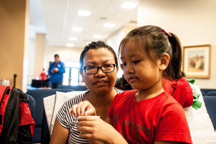 Jie Zhang, 38, and her daughter Sheryl, 8, wait to be entered into the shelter at Lakewood Church in Houston. 