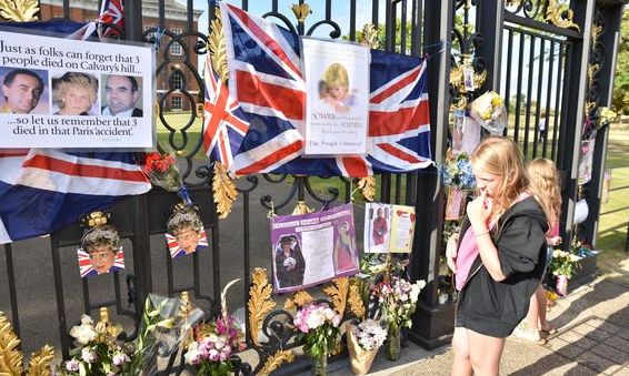 Flowers and tributes begin to appear at the gates of Kensington Palace 