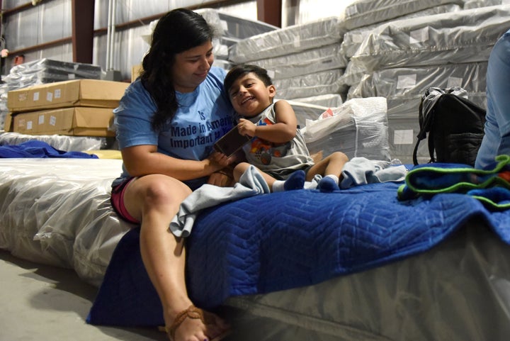 Maria Lopez plays with her son Rafael Lopez, 3, in the Gallery Furniture warehouse where they have been staying after evacuating their flooded home over the weekend.