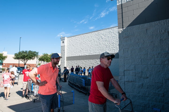 People wait in line to get into Wal-Mart in Katy, Texas on Wednesday. 