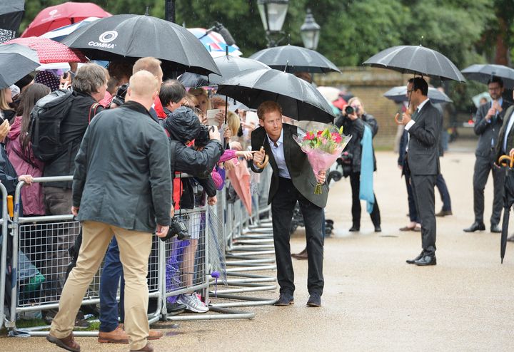 Prince Harry takes a bouquet of flowers from a wellwisher to add to the tributes to Diana.