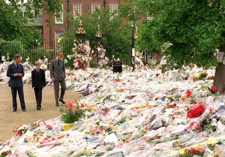 Prince Charles, Prince of Wales, Prince William and Prince Harry look at floral tributes to Diana, Princess of Wales outside Kensington Palace on September 5, 1997 in London.