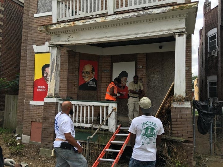 Portraits being hung on an abandoned building.