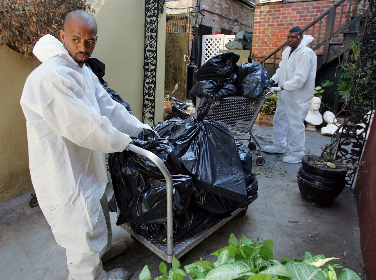 Following Katrina, Cedric Harrell (left) and Tom Miller remove spoiled food from the freezer at Court of Two Sisters restaurant in the French Quarter of New Orleans.