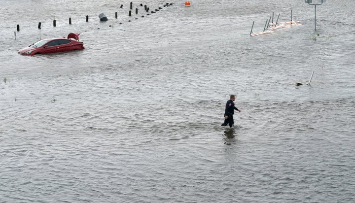 A police officer wades through floodwaters in Alvin, Texas, about 25 miles southeast of Houston.