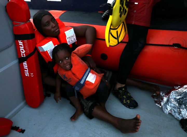 A child reacts as lifeguards of the Spanish NGO Proactiva Open Arms are transporting refugees and migrants onboard a RHIB in central Mediterranean Sea 17 August.
