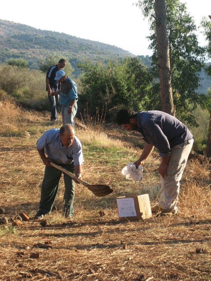 <p>Two men collect the remains of 12-year-old Rami ‘Ali Hassan Shebli, who was killed on October 22, 2006 by a submunition leftover from a cluster munition attack on Halta in Lebanon. Rami unwittingly picked up the submunition while playing with his brother only a couple of hours before this photo was taken.</p>