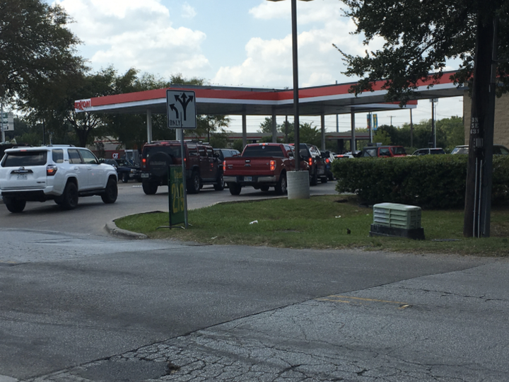 A line of cars forms outside a Dallas Exxon as people wait to fill up.