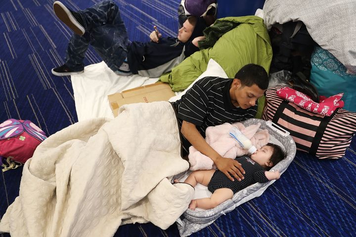 Mark Ocosta and his baby, Aubrey Ocosta, take shelter at the George R. Brown Convention Center after floodwaters inundated Houston on Aug. 29, 2017.