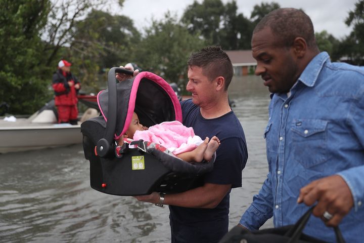 A rescue worker carries a baby to dry land in Port Arthur, Texas, on Aug. 30, 2017.