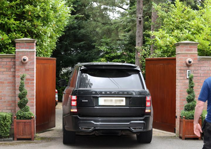 A car goes through the gates of Rooney's home