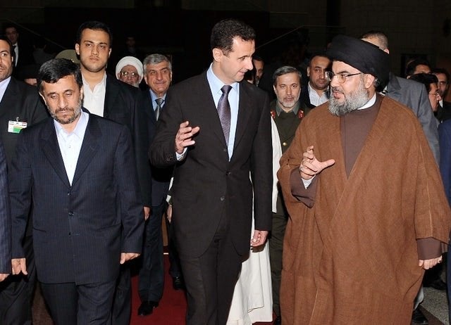 A photo released by the Syrian Arab News Agency (SANA) shows (L–R) former Iranian president Mahmoud Ahmadinejad, his Sy