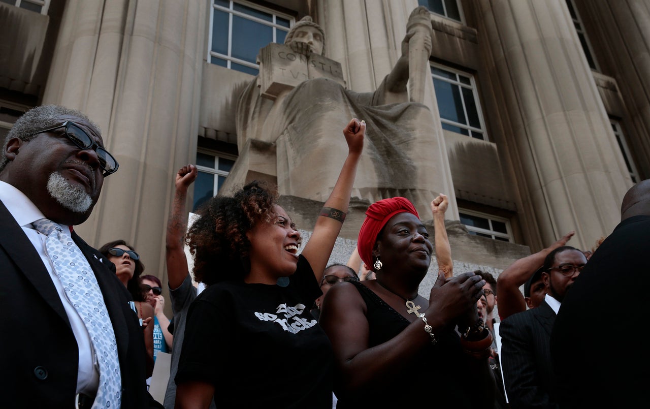 LaShell Eikerenkoetter, center, and Julia Davis cheer the words of area clergy who called for a guilty verdict in the shooting death of Anthony Lamar Smith by former St. Louis police Officer Jason Stockley.