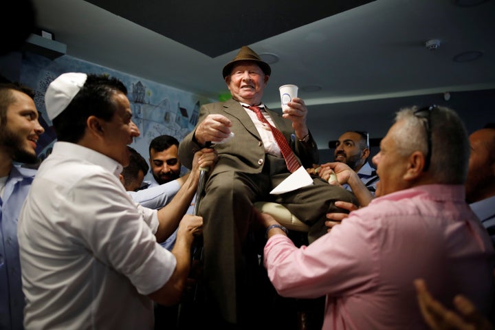 Shalom Shtamberg, a 93-year old Holocaust survivor, is lifted on a chair during celebrations marking his bar mitzvah ceremony