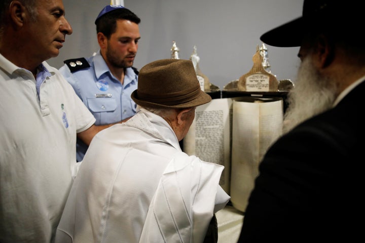 Shtamberg reads from a Torah scroll.