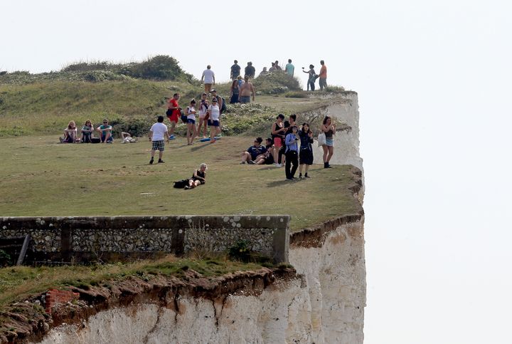 People on the cliffs at Birling Gap in Eastboune, Sussex, part of a stretch of coastline that was evacuated on Sunday after a chemical 'haze' caused illness