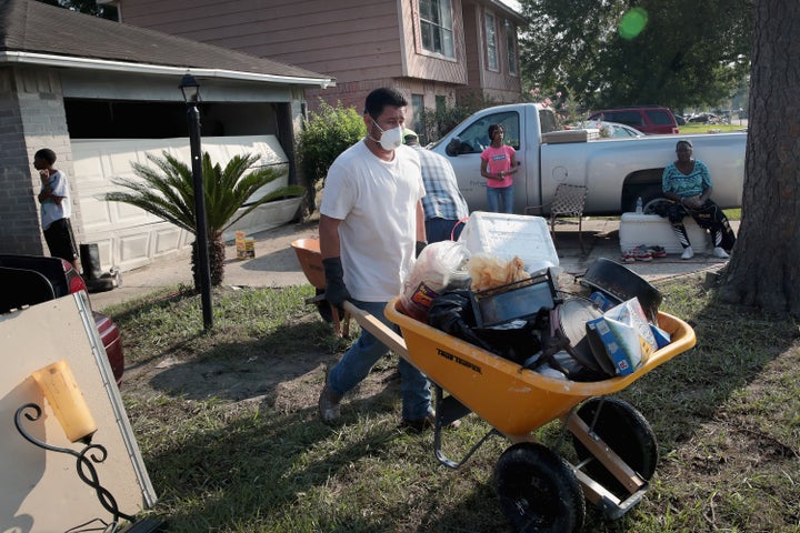 Volunteers from Performance Contractors help a co-worker clean up the damage to his Houston home after Hurricane Harvey.