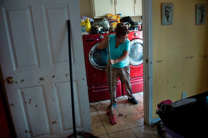 A woman cleans the floors of a once flooded house in Houston.