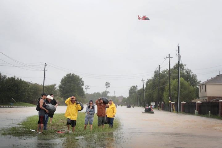 Residents make their way out of a flooded neighborhood in Houston on Monday. President Donald Trump has officially requested Congress approve $7.85 billion for relief efforts in Texas and Louisiana.