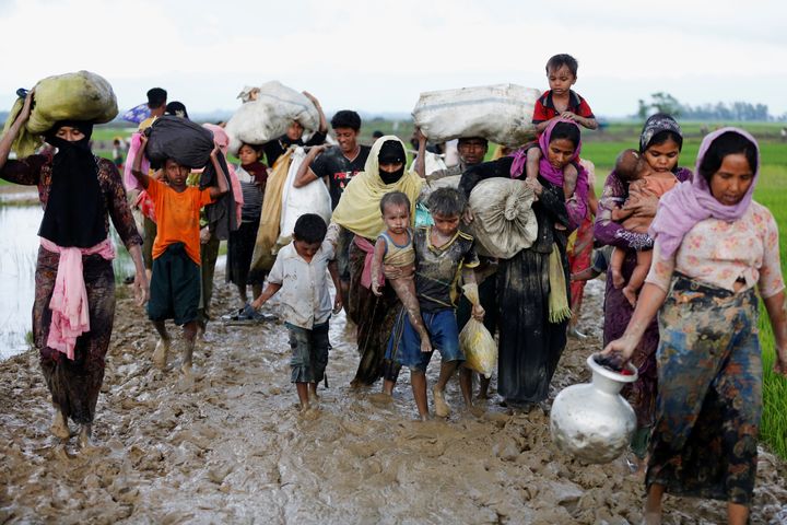 A group of Rohingya refugees walk on the muddy road after travelling over the Bangladesh-Myanmar border in Teknaf, Bangladesh, September 1, 2017. 