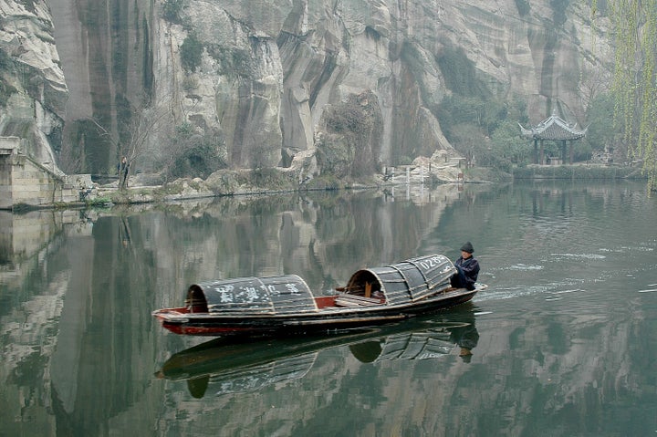 Traditional boats powered by oars pushed by feet, at East Lake, a preserved village in Zhejiang