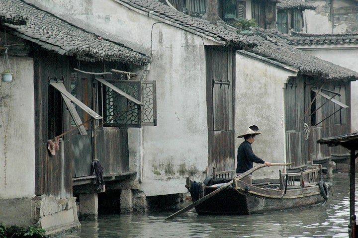  A boatman at Wuzhen, one of the ancient river towns, has been preserved in Zhejiang Province as a living history museum ��Rc��