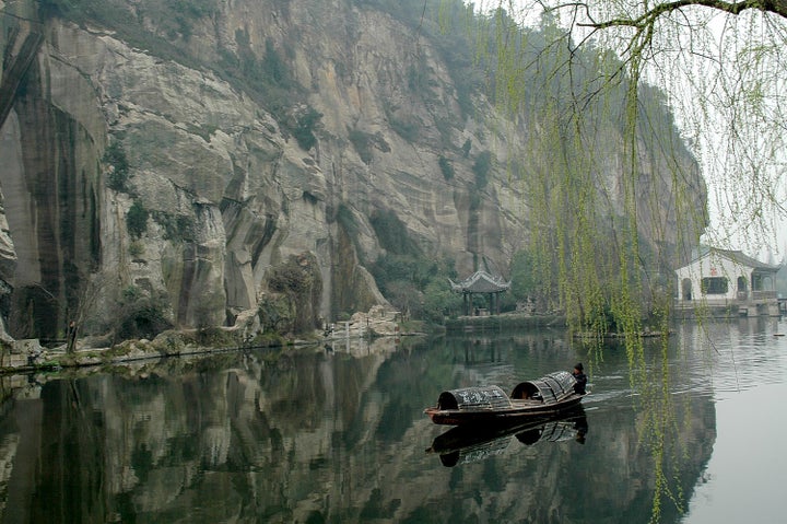 <p> <em>One of the famous “black boats,” which the oarsman powers by his feet, glides along East Lake</em> </p>