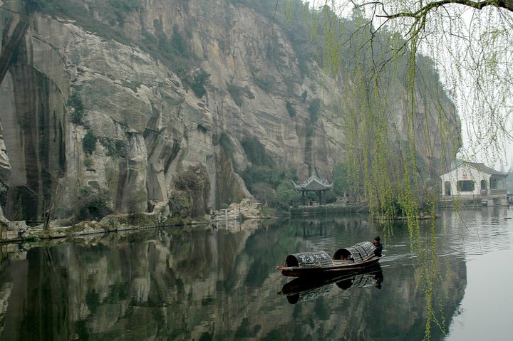  One of the famous “black boats,” which the oarsman powers by his feet, glides along East Lake 