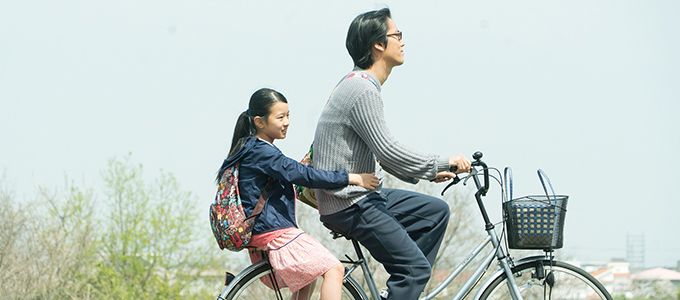 Tomo (Rinka Kakihara) rides behind her uncle Makio (Kenta Kiritani) in a scene from Close-Knit 
