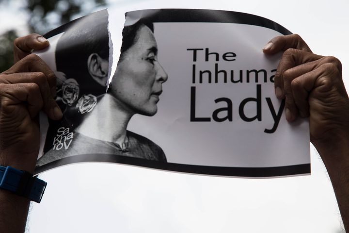 An Indonesian protester tears a picture of Myanmar's Aung San Suu Kyi during a rally in front of Myanmar embassy in Jakarta