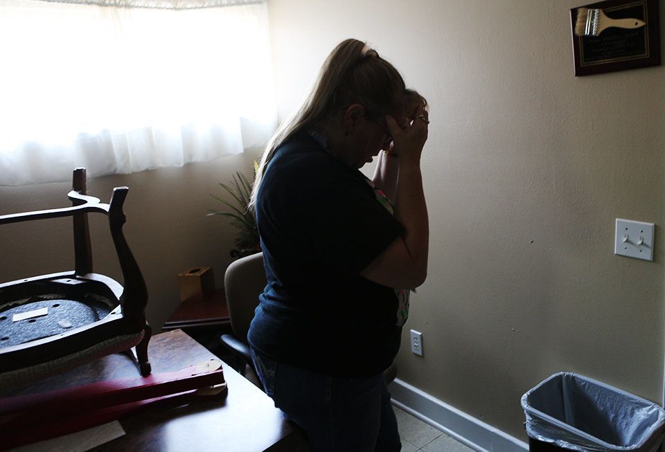 Mary Woods holds her head in her hands as she shows off some of the damage Harvey left at the domestic violence shelter she works at in Humble, Texas.