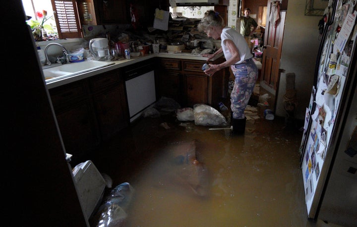 Nancy McBride collects items from her flooded kitchen as she returned to her home on Sept. 1, 2017, for the first time since floods caused by Hurricane Harvey inundated Houston.