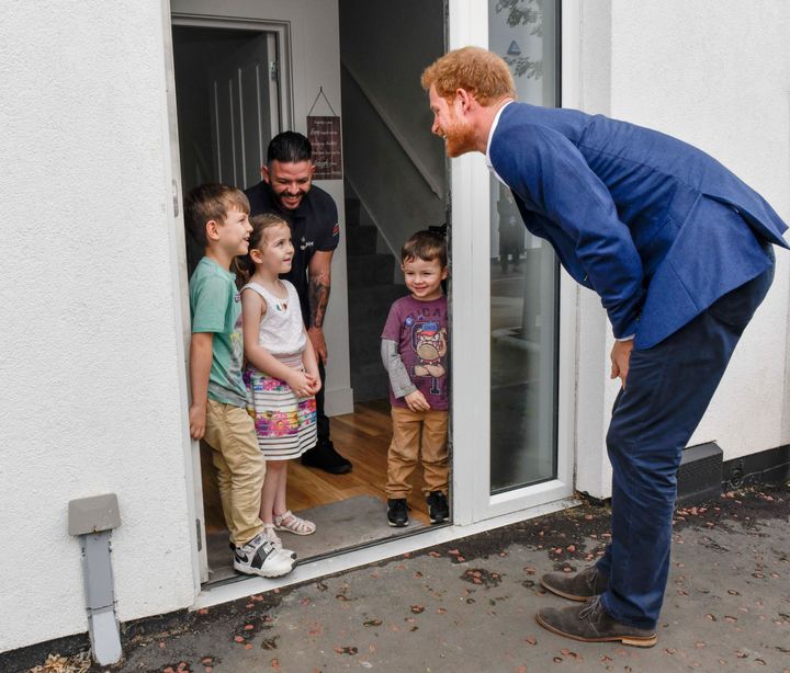 Prince Harry meets 5 year old Lily Anne Flores and her brothers Kobbi and Damaso and her father Simon Flores .