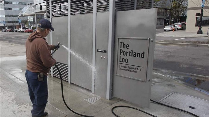 <p>A man hoses down a Portland Loo in Portland, Oregon.</p>