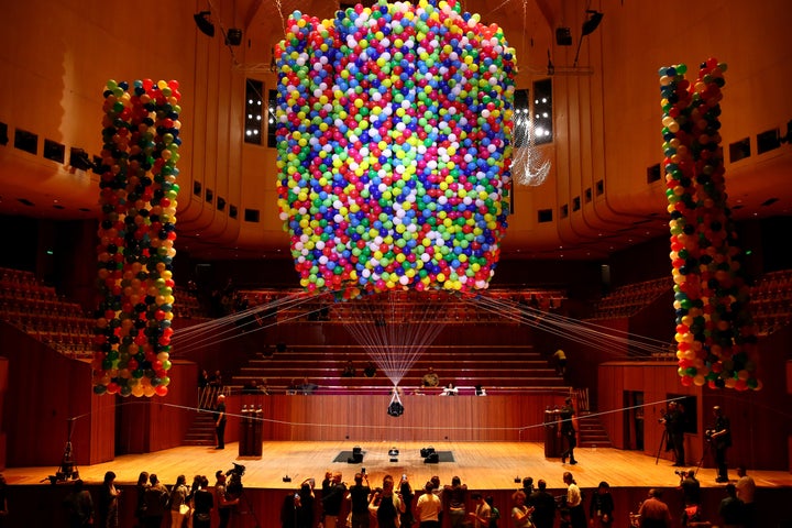 Austrian British artist Noëmi Lakmaier is seen suspended by 20,000 helium-filled balloons inside of the Sydney Opera House on Sunday.