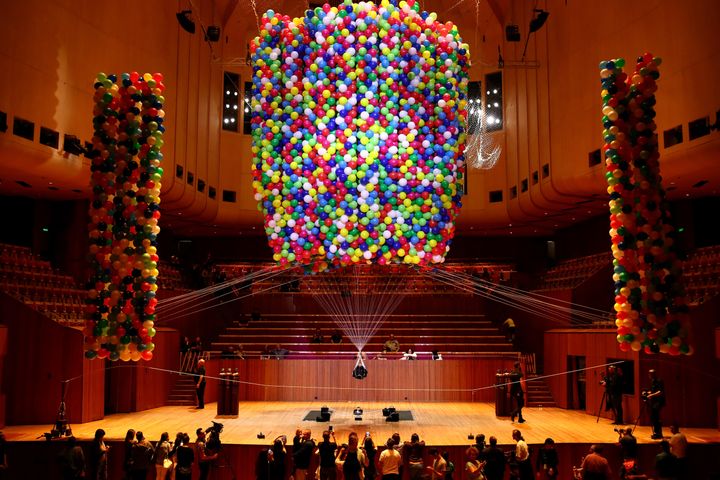 Austrian British artist Noëmi Lakmaier is seen suspended by 20,000 helium-filled balloons inside of the Sydney Opera House on Sunday.