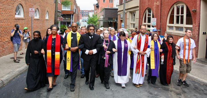 Dr. Cornel West walking with group of clergy on a march to downtown Charlottesville, where they knelt in prayer on the south edge of Emancipation Park and stood singing “This Little Light of Mine”. Credit: Jordy Yager. 