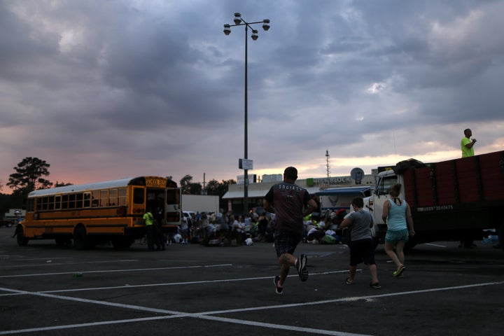 Evacuees in Vidor, Texas, rescued from the floodwaters of Tropical Storm Harvey run toward a school bus bound for Louisiana o