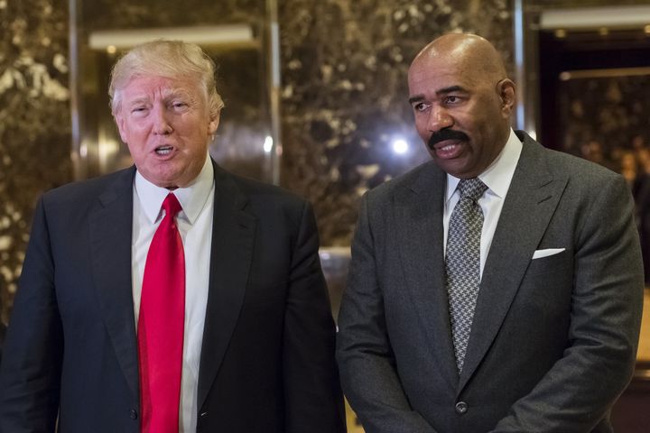 President Donald Trump, left, speaks to members of the media as comedian and television host Steve Harvey stands in the lobby of Trump Tower in New York, U.S., on Friday, Jan. 13, 2017. 
