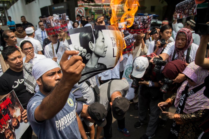 An Indonesian protester burns a picture of Myanmar's Aung San Suu Kyi during a rally in front of Myanmar's embassy in Jakarta