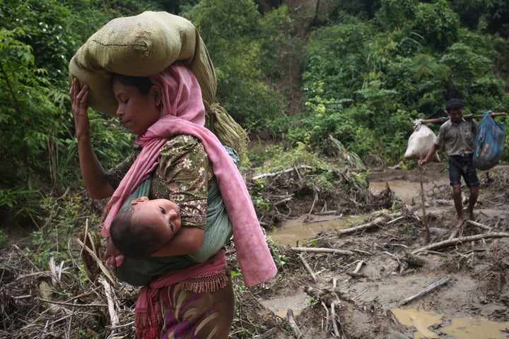 A Rohingya woman carries her child in a sling after crossing the border into Bangladesh on Sept. 5, 2017.