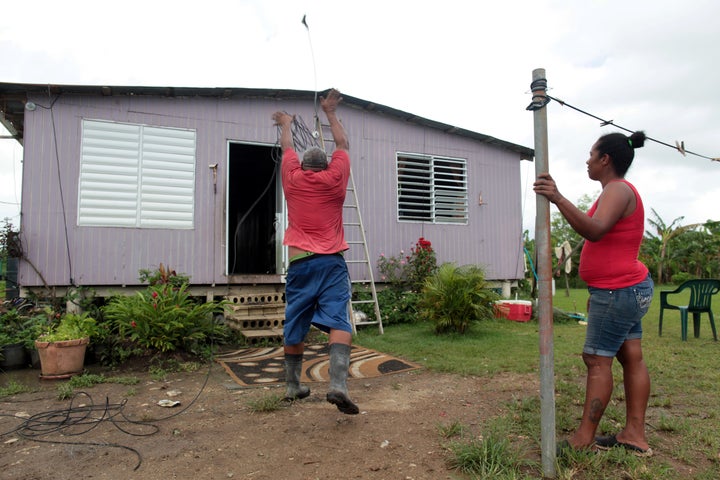 A man uses a cable to secure the roof of his home in preparation for Hurricane Irma, in Toa Baja, Puerto Rico.