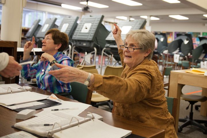 Ann Moss checks a voter's ID in Houston. Texas' voter ID law is considered one of the strictest in the U.S.