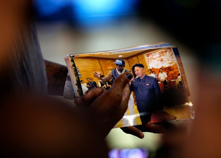 <strong>Rodman shows a picture which he took with North Korean leader Kim Jong-un as he arrives at Beijing Capital International Airport inSeptember, 2013</strong>