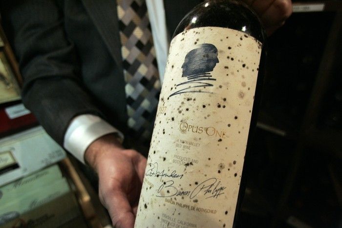 A sommelier in New Orleans displays a mold-damaged bottle of Opus One 1997 after Katrina. 