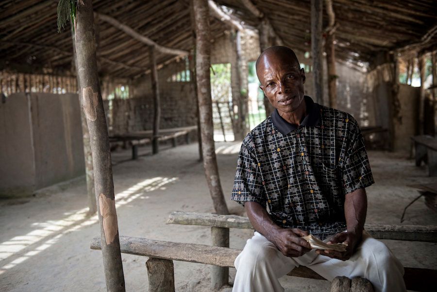 Jean de-Dieu Liyande, a former sleeping sickness patient, sits in his village church.