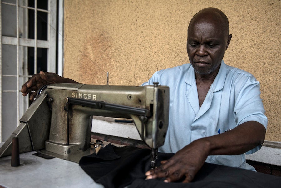 Thomas Disolo sews a tsetse fly trap at the Ministry of Health.