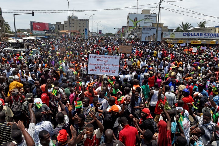 Protesters carry placards while they march shouting slogans as they call for reforms during an anti-government rally in Lome