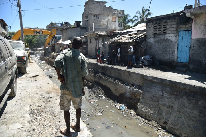 A man watches while a bulldozer clean debris in a canal, in Cap-Haitien, on September 6, 2017, 240 km from Port-au-Prince, in preparation before the arrival of Hurricane Irma. 